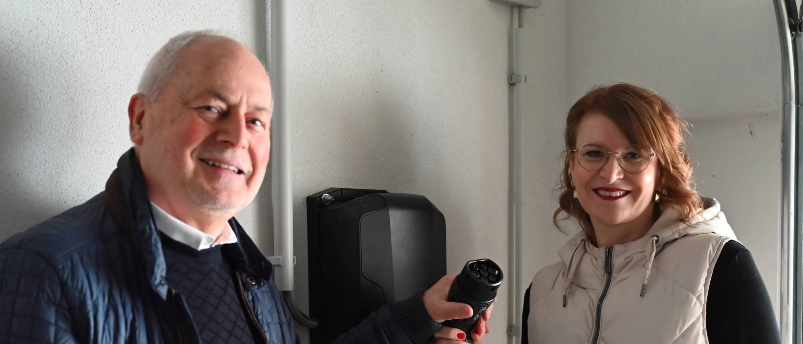 Djamila Neutert, Teamleiterin Energiedienstleistungen bei den Stadtwerken Energie, und Hausverwalter Rainer Raithel bei der Übergabe der Wallboxen.  
