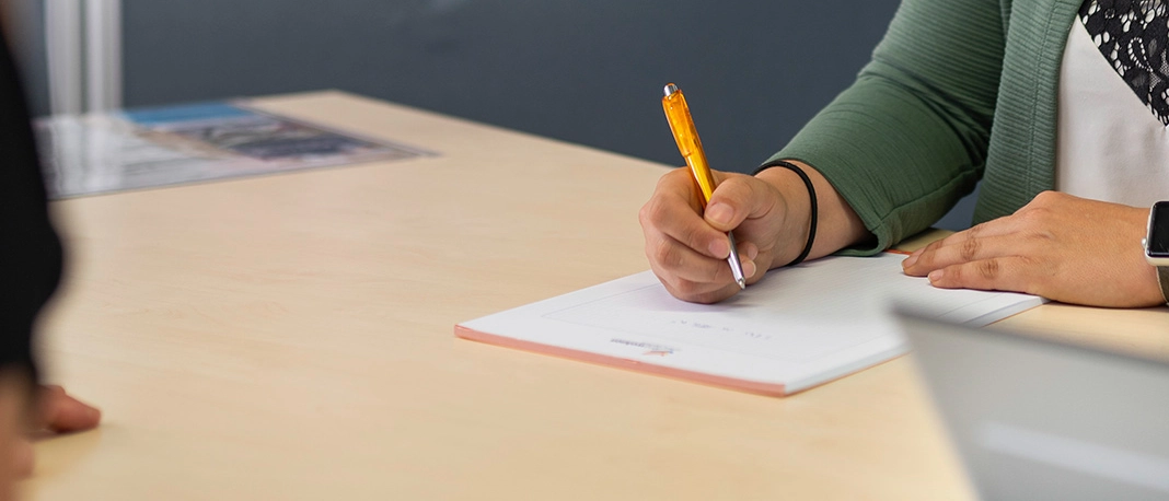 Eine Frau füllt ein Formular im jenawohnen-Kundencenter aus