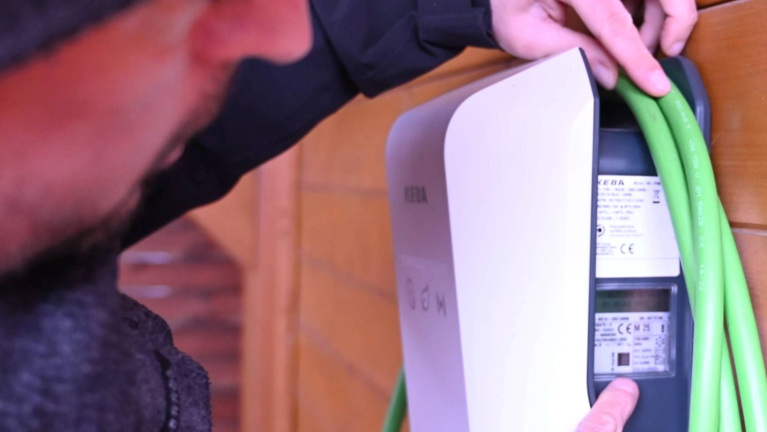 Dennis Beyermann zeigt auf die seitliche Beschriftung der Wallbox.
