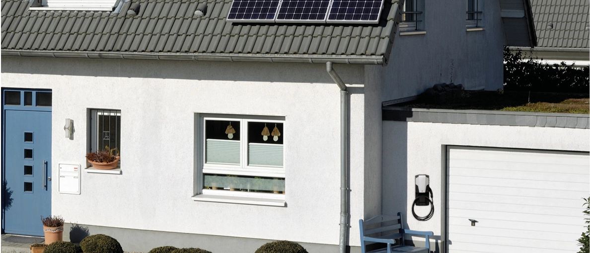 Wohnhaus mit PV-Dach und Wallbox an Hauswand