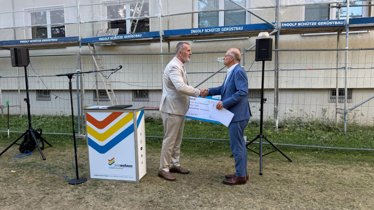 Fördermittelübergabe für die Ernst-Schneller-Straße 8 in Jena-Lobeda: Thüringens Minister für Digitales und Infrastruktur, Steffen Schütz, übergibt den Scheck an jenawohnen Geschäftsführer Tobias Wolfrum 