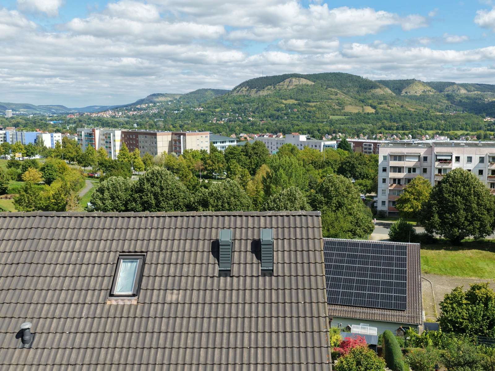 Doppelhaushälfte in Jena-Winzerla mit installierter Wärmepumpe auf dem Dach und Blick auf die Umgebung.