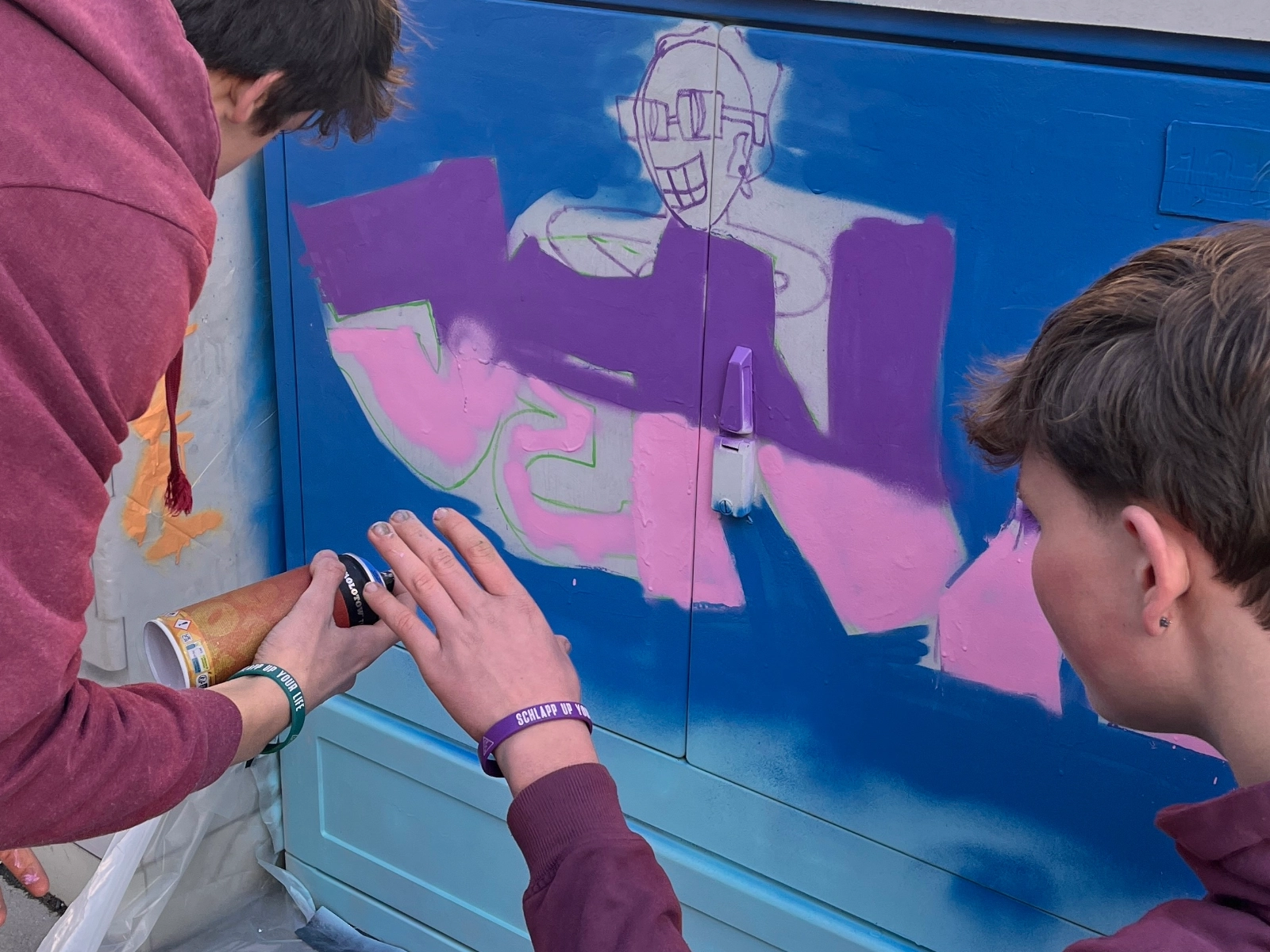 Schüler gestalten einen Stromkasten.