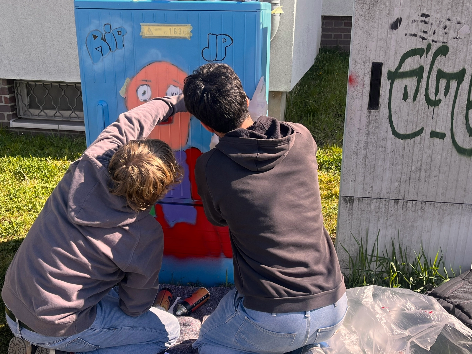 Schüler gestalten einen Stromkasten.
