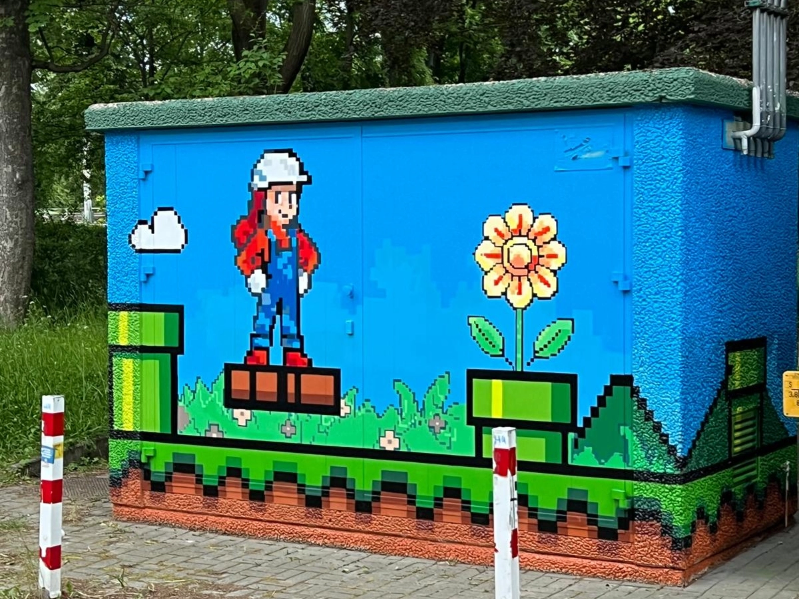 Auf den Anlagen am Alexander-Puschkin-Platz finden sich Pilze, Blumen und grüne Rohre und auch ein paar niedliche Bauarbeiter(innen) in rot-blauen Latzhosen.