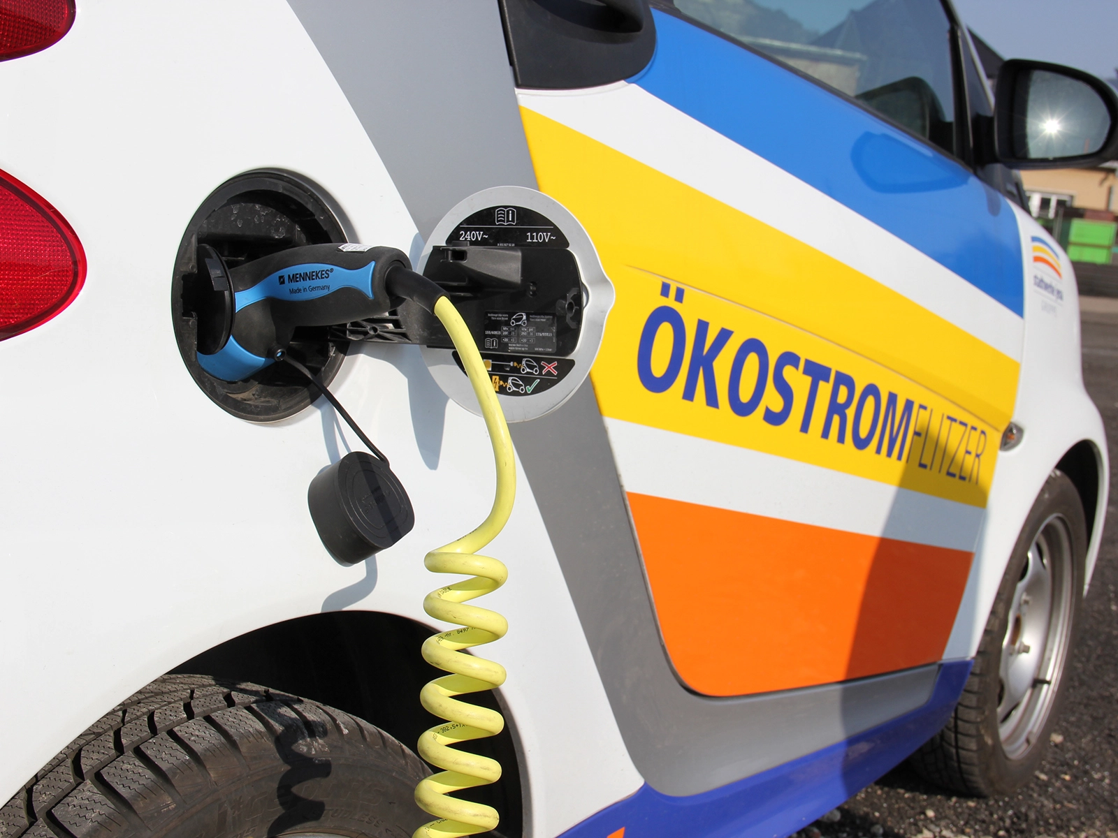 Elektroauto mit Aufdruck Ökostromflitzer wird geladen