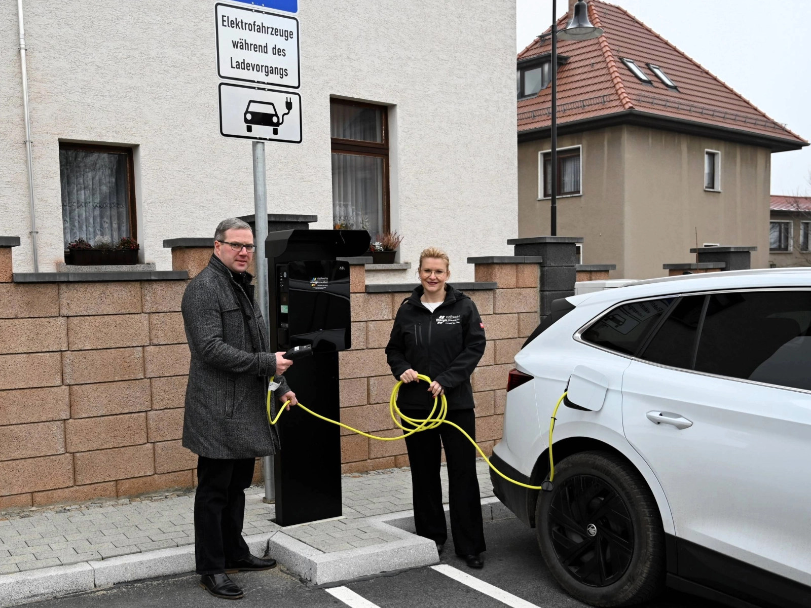 Hermsdorfs Bürgermeister Benny Hofmann und Djamila Neutert von den Stadtwerken Energie an den neuen Ladepunkten in der Hermsdorfer Schulstraße. 