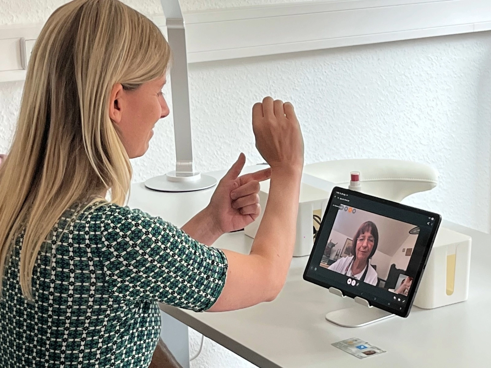Telemedizin per Tablet: Digitale Videosprechstunde zur medizinischen Beratung und Untersuchung des Arms.