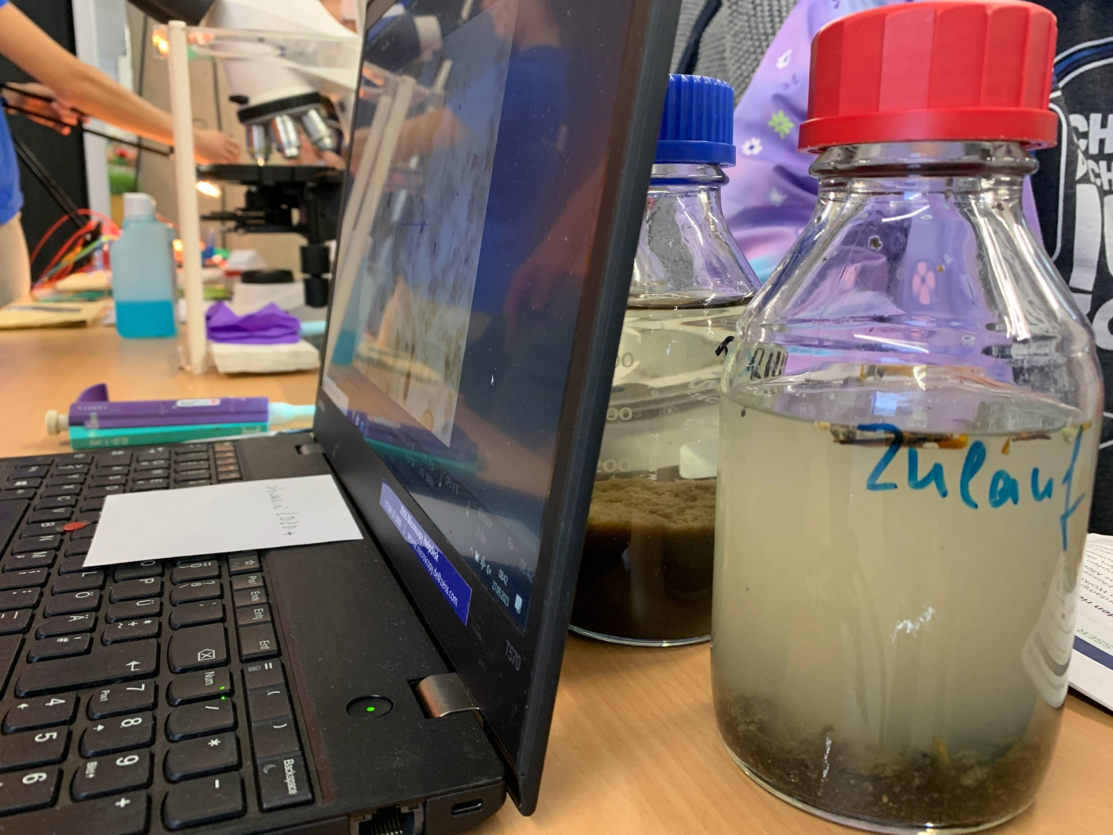 Ein PC und eine Glasflasche mit Experimentierflüssigkeit Ein PC und eine Glasflasche mit Experimentierflüssigkeit