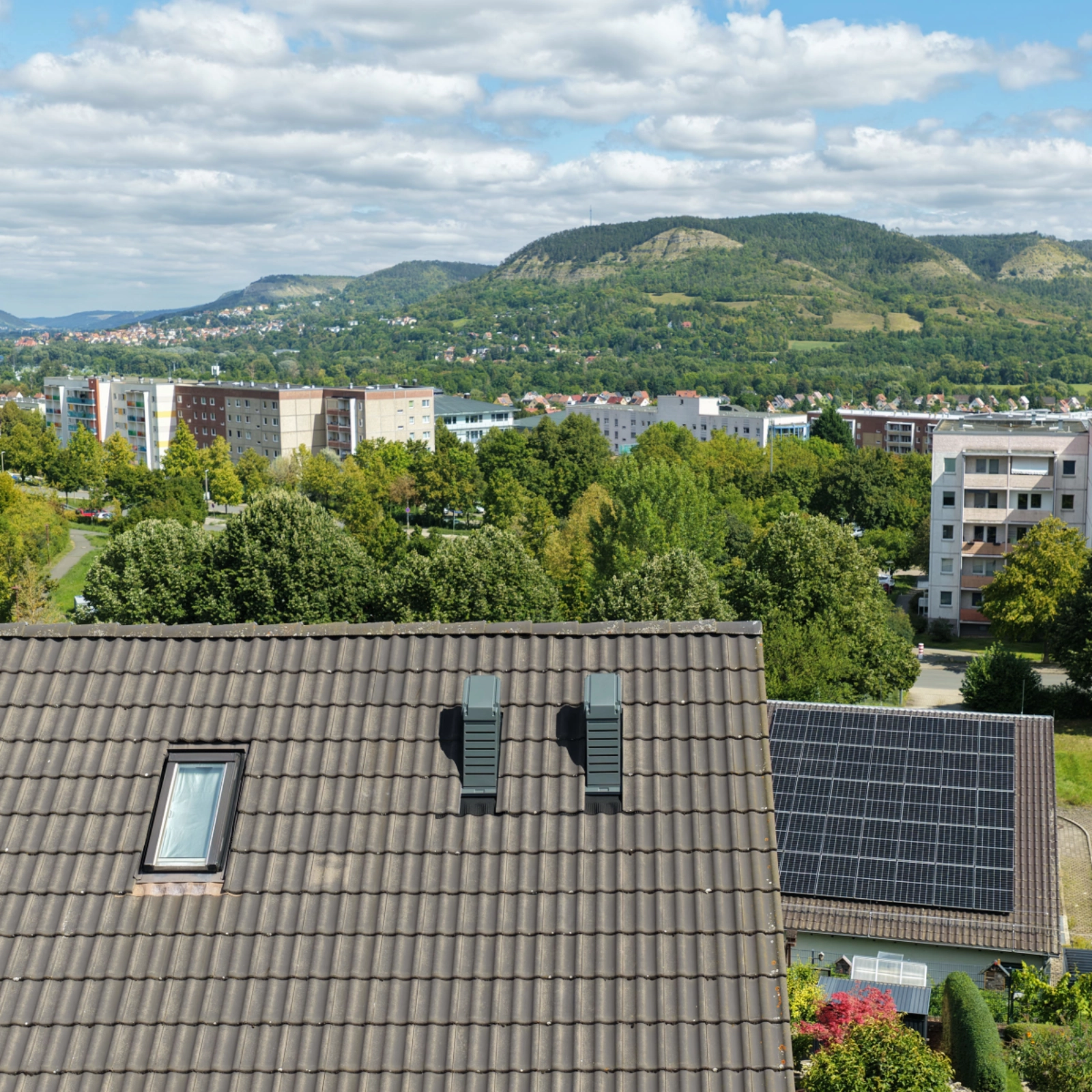 Doppelhaushälfte in Jena-Winzerla mit installierter Wärmepumpe auf dem Dach und Blick auf die Umgebung.