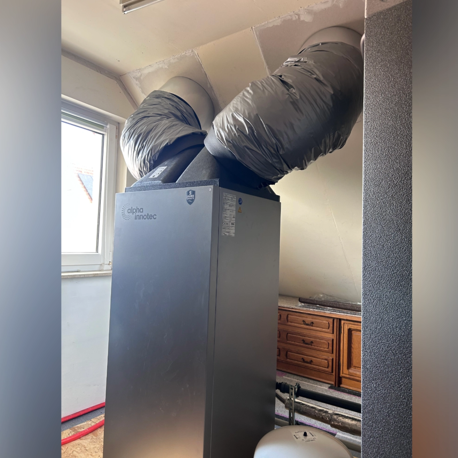 Innenansicht der Wärmepumpenanlage mit Luftkanälen im Dachgeschoss des Wohnhauses.