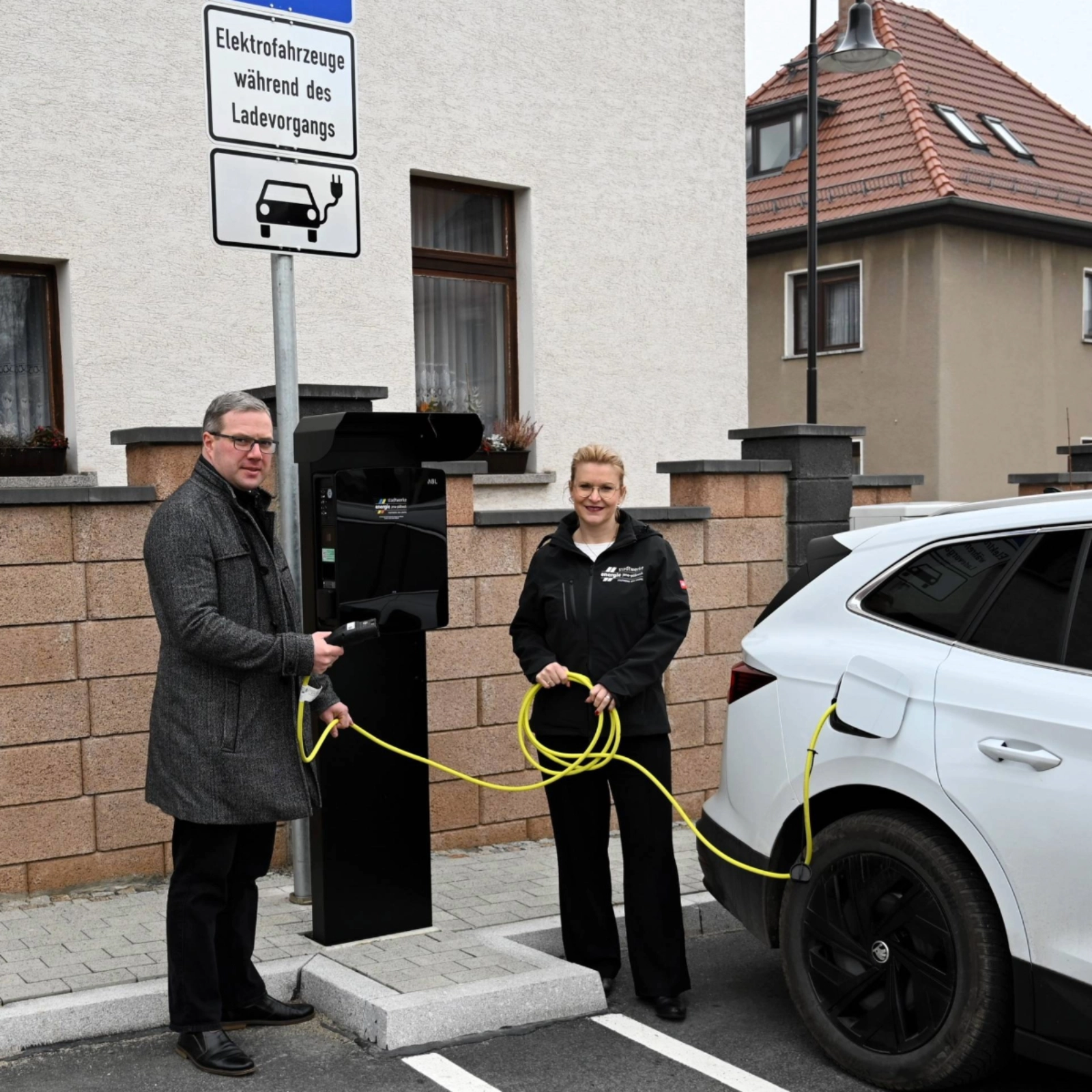Hermsdorfs Bürgermeister Benny Hofmann und Djamila Neutert von den Stadtwerken Energie an den neuen Ladepunkten in der Hermsdorfer Schulstraße. 