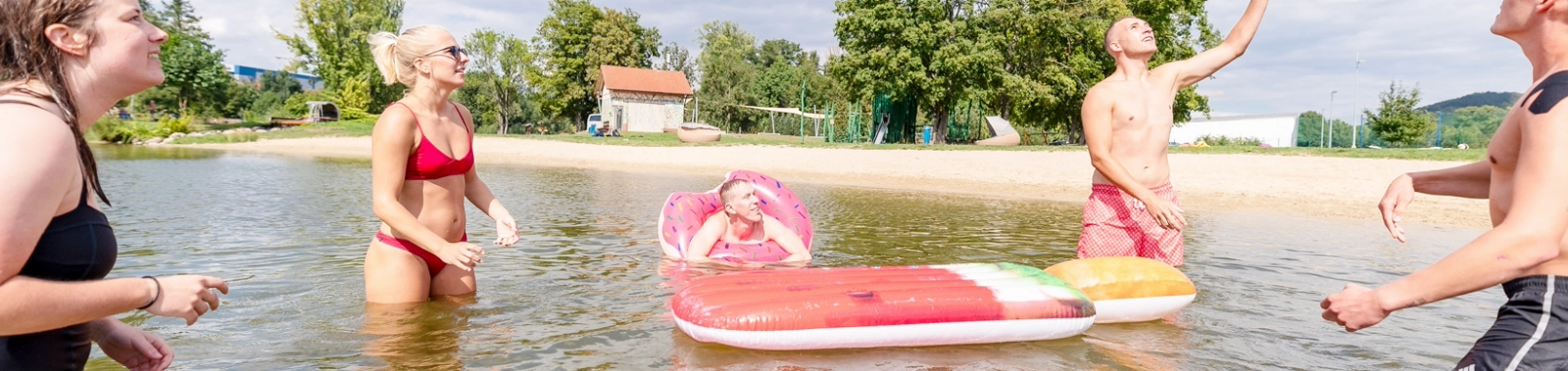 Badegäste spielen mit einem Ball im Schleichersee.