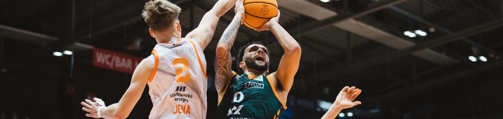 Basketballspieler von Science City Jena und einer gegnerischen Mannschaft im Sprung