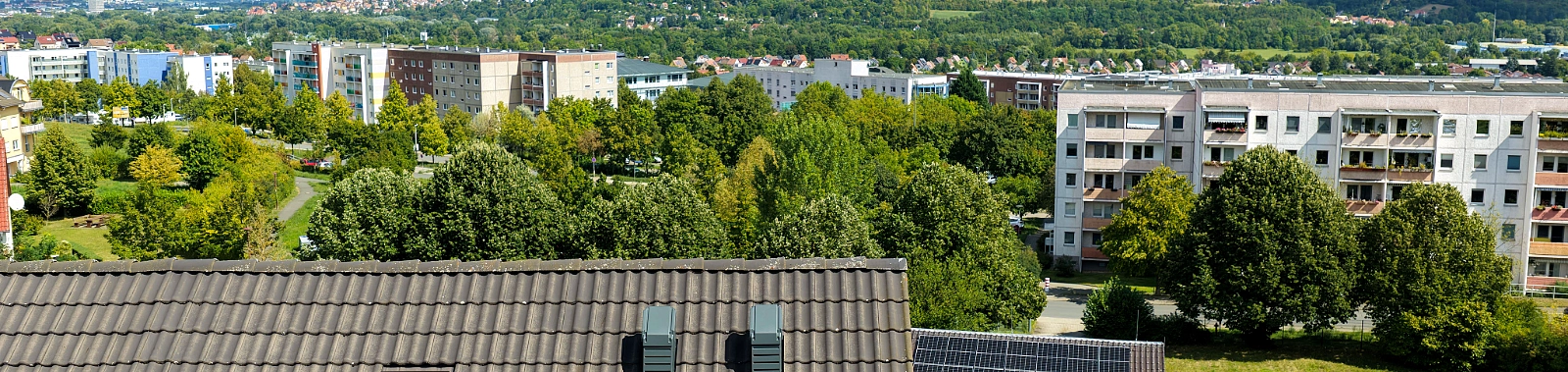 Doppelhaushälfte in Jena-Winzerla mit auf dem Dach installierter Wärmepumpe und Blick über den Stadtteil.