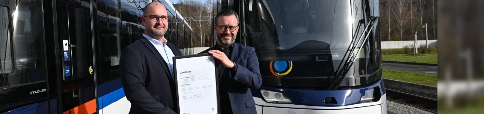 Gemeinsam zertifiziert: Steffen Gundermann (Jenaer Nahverkehr und JES) und Christian Lindau (links, Stadtwerke Energie Jena-Pößneck) präsentieren das ISO-50001-Zertifikat für das neue Energiemanagementsystem. 