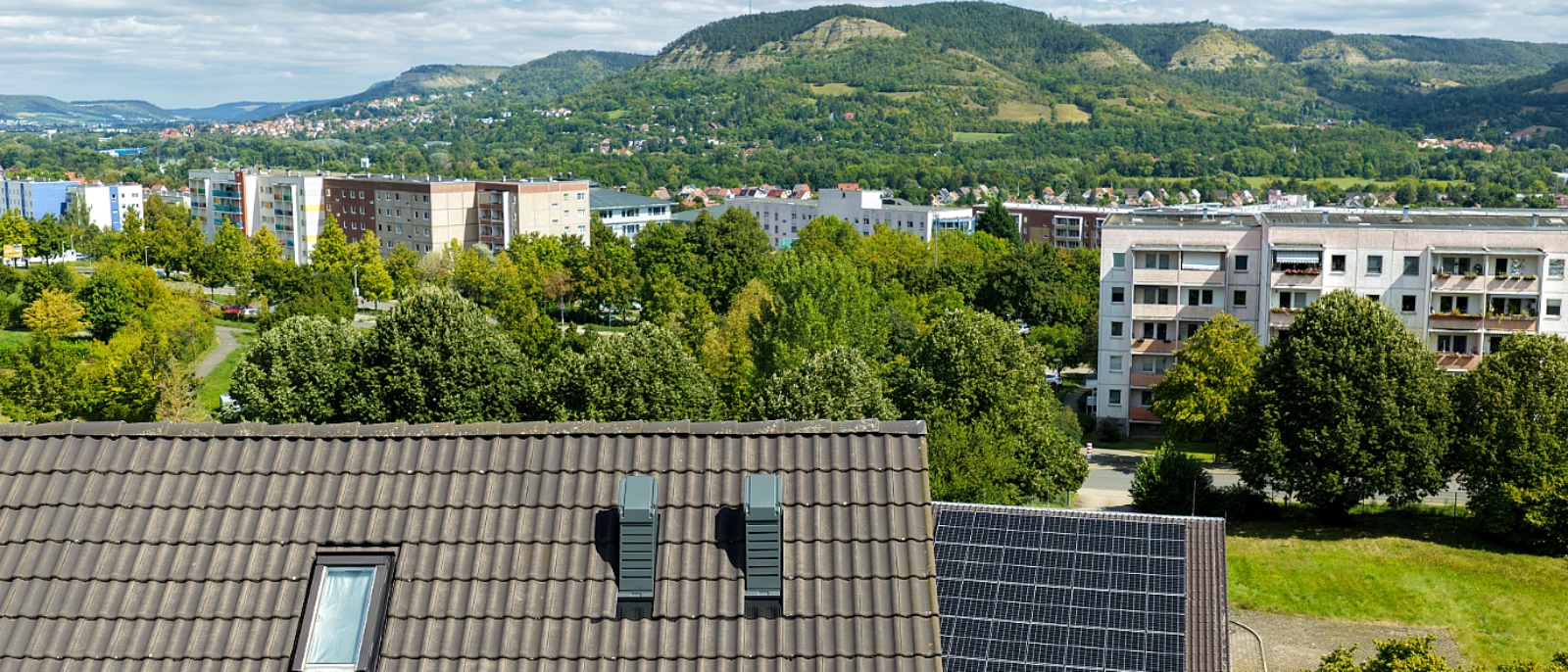 Doppelhaushälfte in Jena-Winzerla mit auf dem Dach installierter Wärmepumpe und Blick über den Stadtteil.