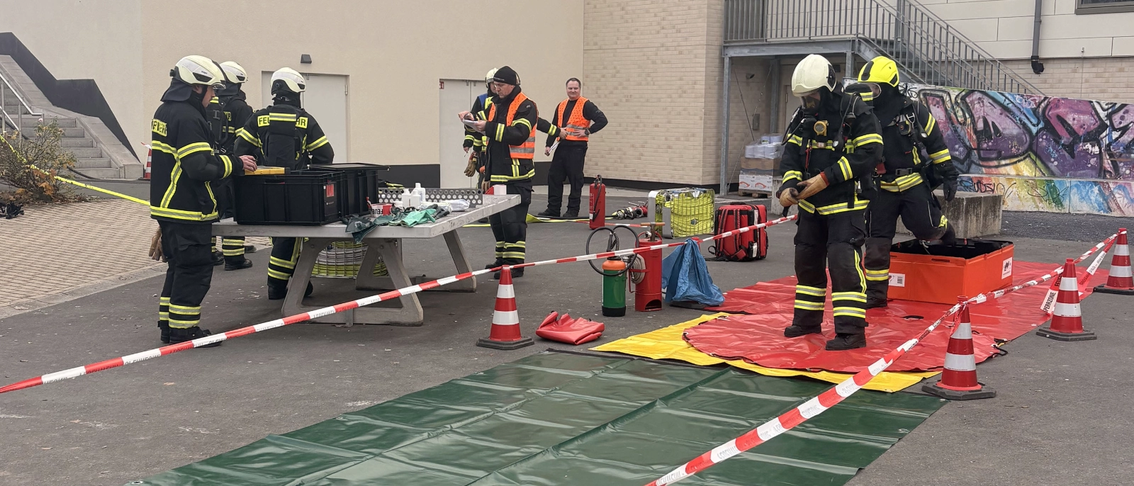 Im Übungsverlauf war ein Techniker unter einem Behälter eingeklemmt, während eine weitere Mitarbeiterin durch den ausgetretenen Gefahrstoff verletzt wurde. 