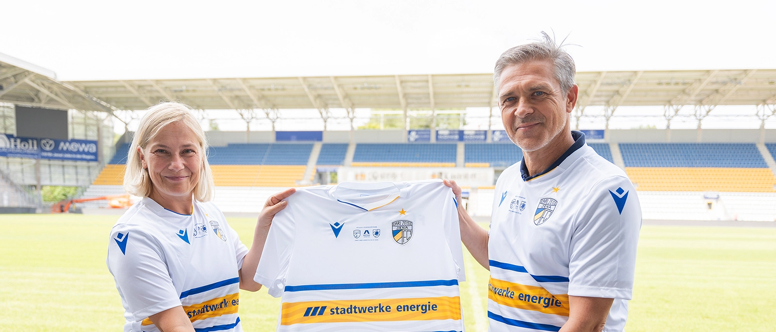 Stadtwerke Energie-Geschäftsführerin Claudia Budich und FCC-Trainer Henning Bürger präsentieren das Sondertrikots zum Eröffnungsspiel für die neue ad hoc Arena im Ernst-Abbe-Sportfeld
