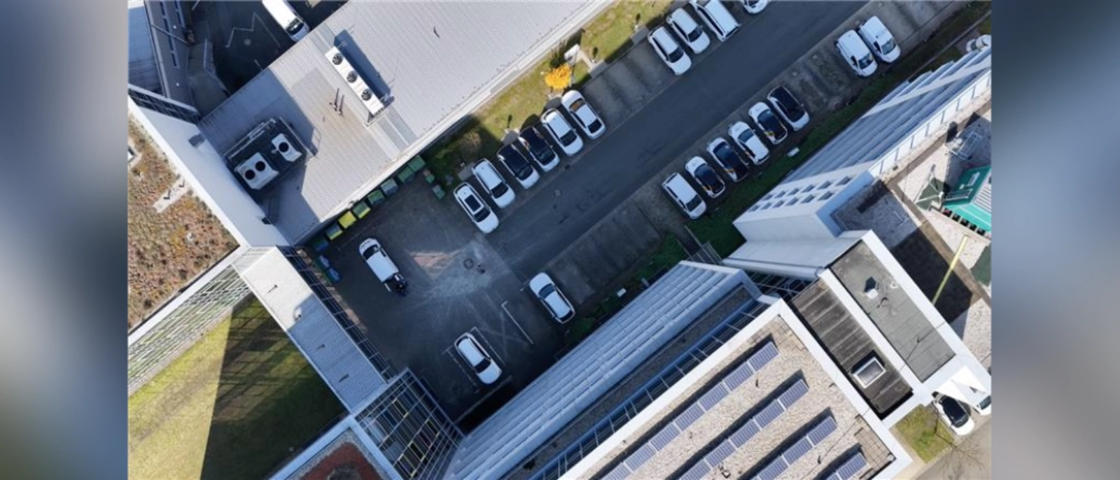 Luftaufnahme des Fuhrparks der Jeneaer Stadtwerke mit parkenden Autos.