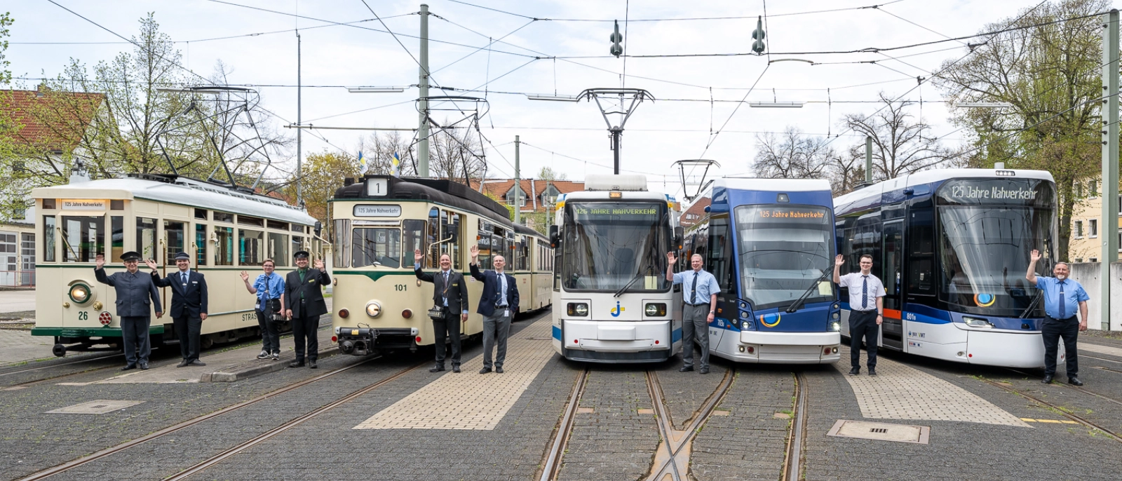 Historische und moderne Straßenbahnen stehen nebeneinander im Depot