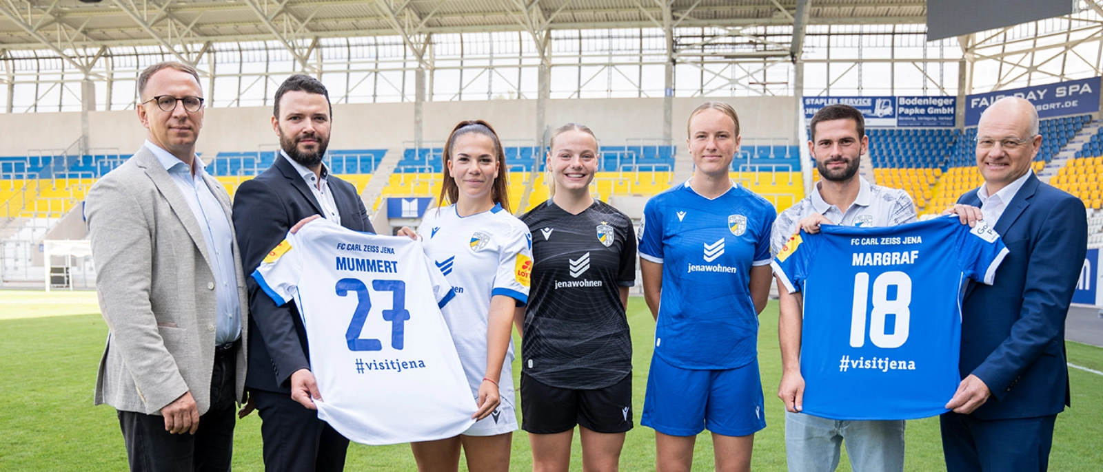 jenawohnen Geschäftsführer präsentiert Trikot der FCC Frauen mit Spielerinnen, Sportdezernent und Werkleiter JenaKultur