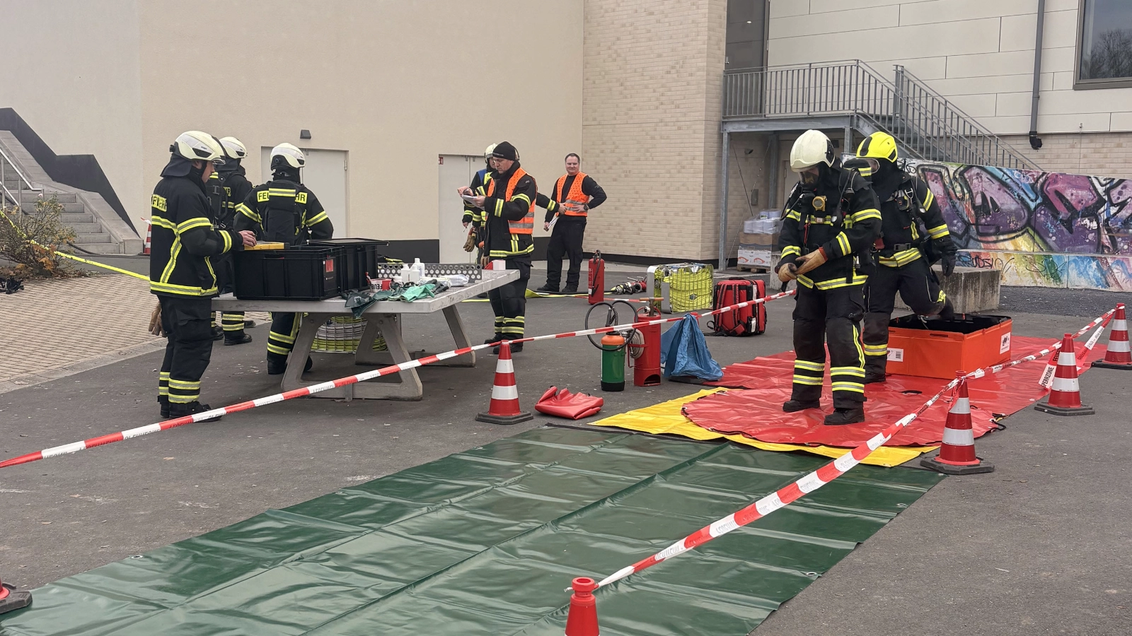 Im Übungsverlauf war ein Techniker unter einem Behälter eingeklemmt, während eine weitere Mitarbeiterin durch den ausgetretenen Gefahrstoff verletzt wurde. 