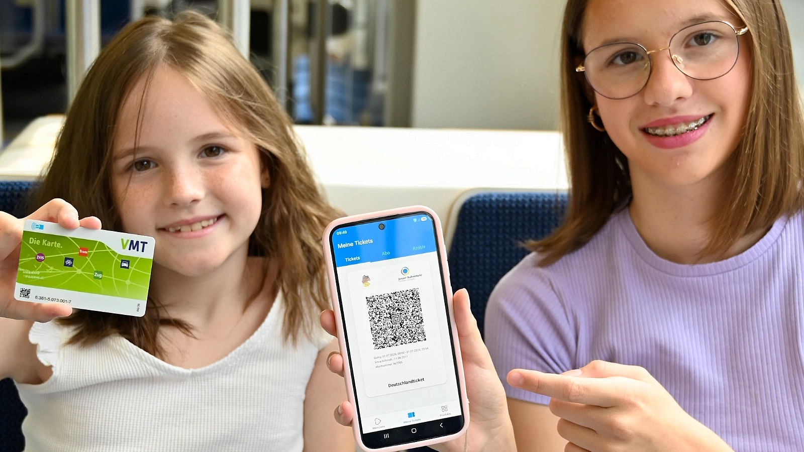 Kinder zeigen Deutschlandticket in der MeinJena-App und als Chipkarte im öffentlichen Nahverkehr in Jena.