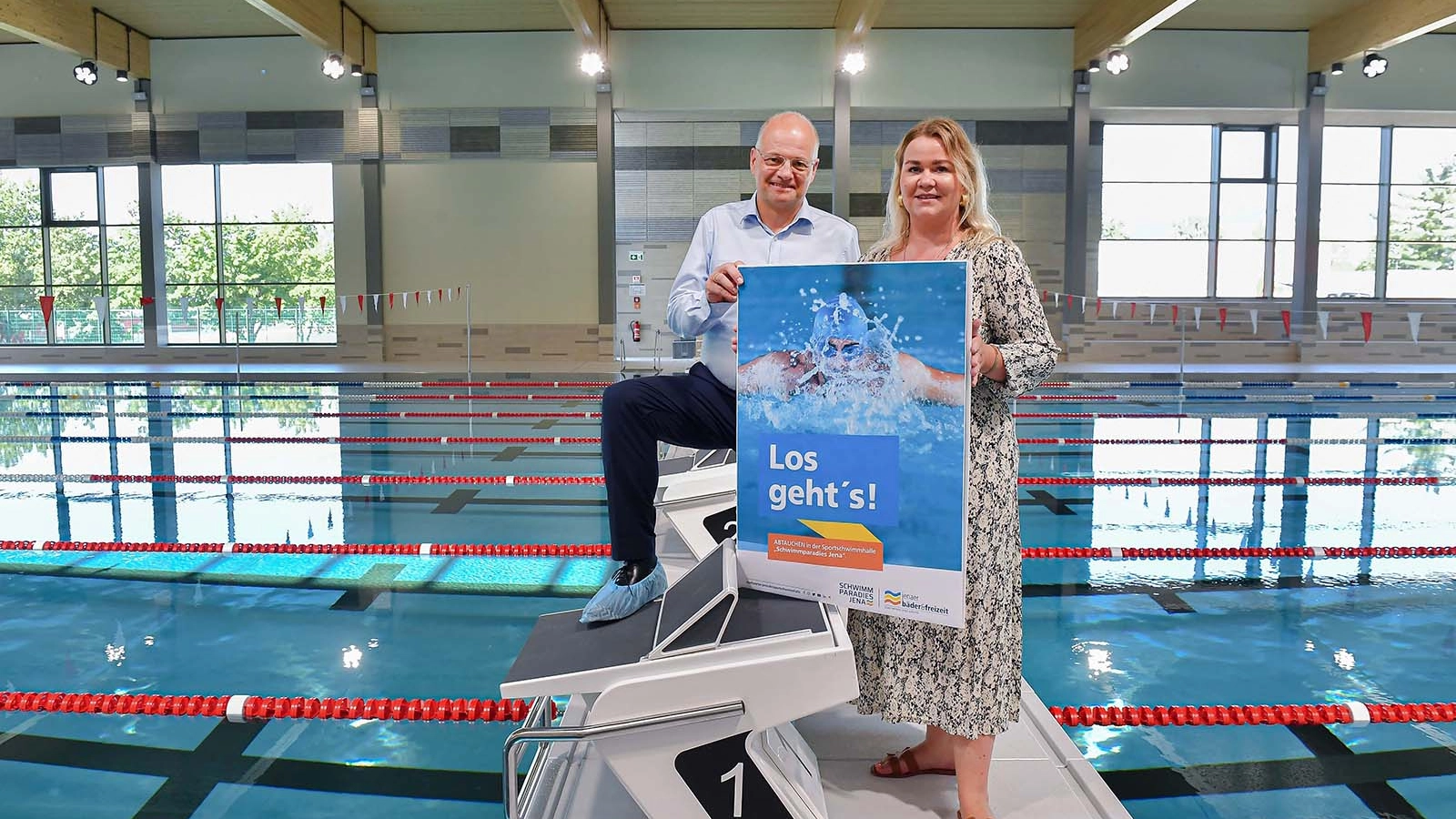 Zwei Personen stehen in der Sportschwimmhalle