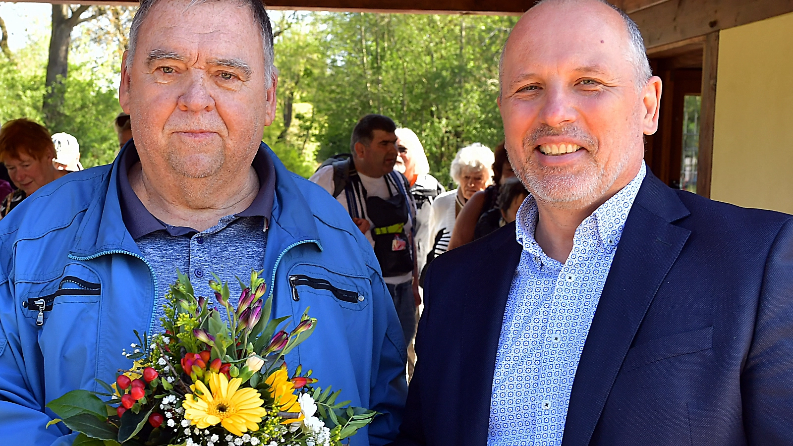 Zum Auftakt der Freibadsaison im Südbad begrüßt Geschäftsführer Bernhard Dengel (rechts) den ersten Badegast, Frank Köber, persönlich mit einem Blumenstrauß und einem sommerlichen Strohhut. 