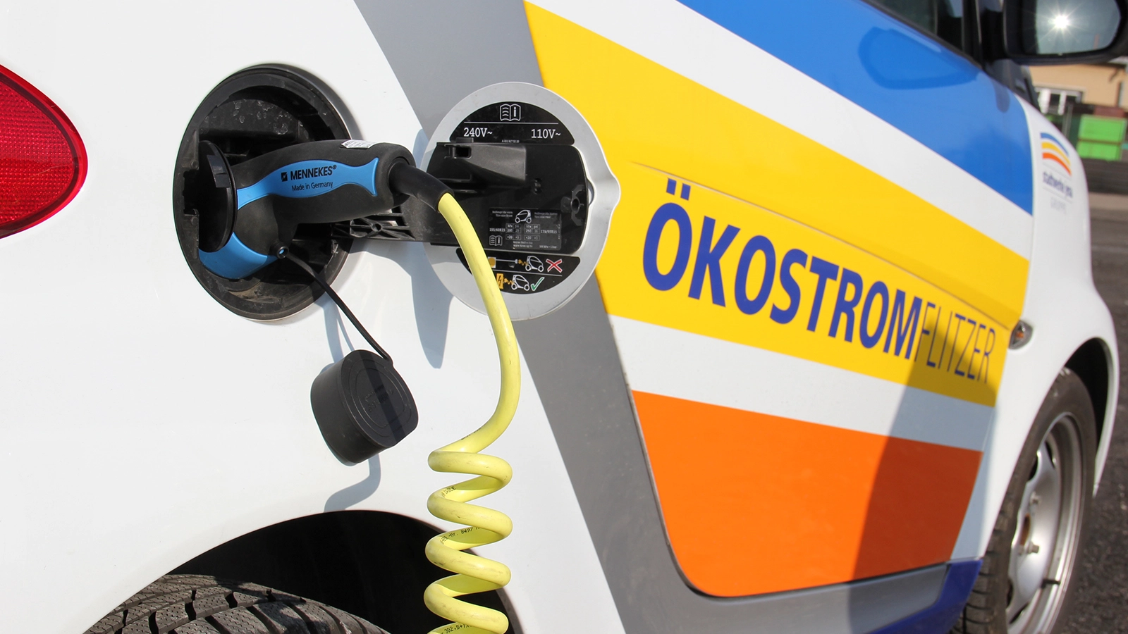 Elektroauto mit Aufdruck Ökostromflitzer wird geladen