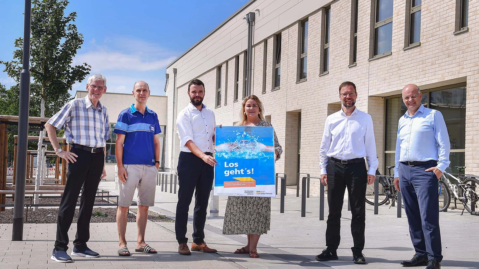 Sechs Personen stehen vor der Sportschwimmhalle 