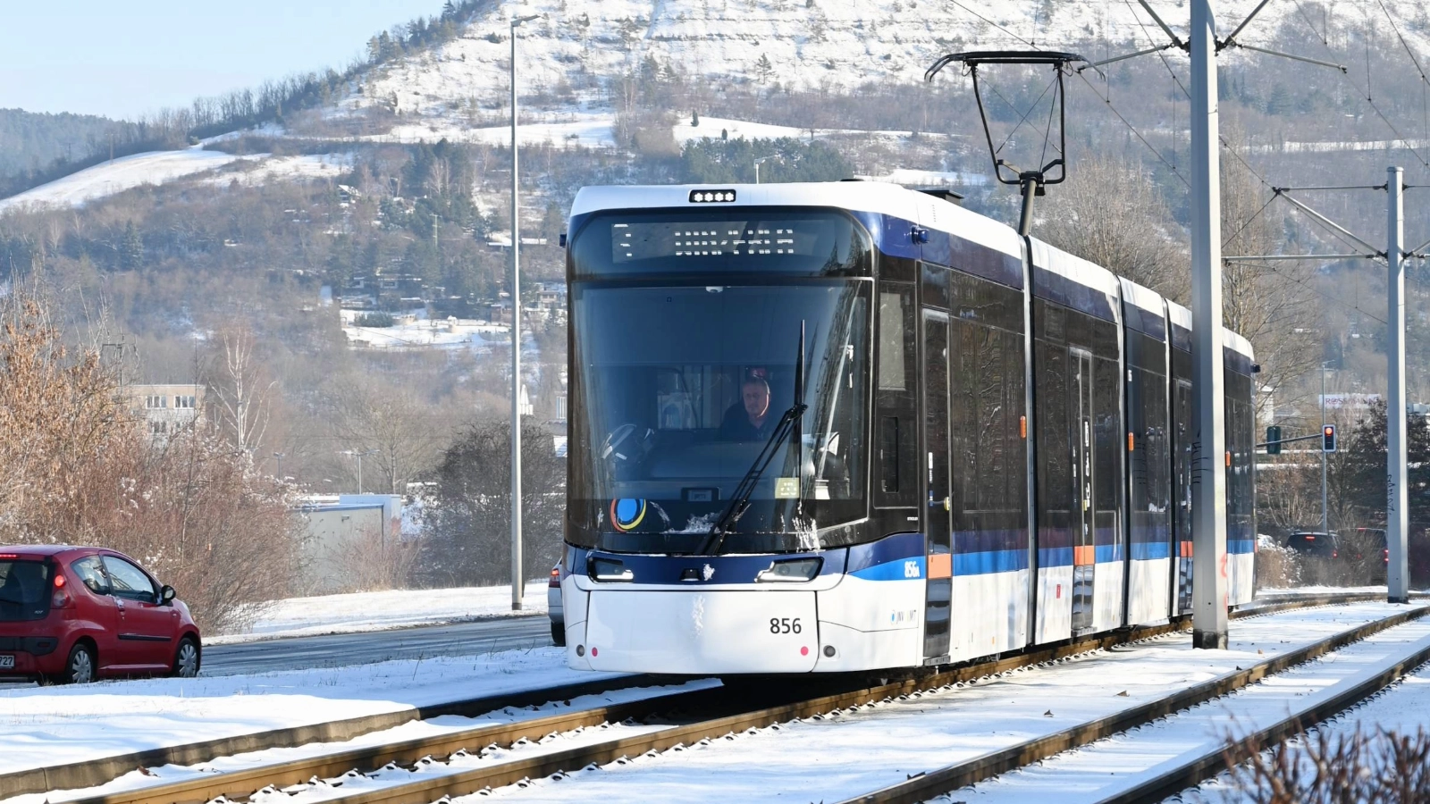 Eine Bahn fährt bei Schnee durch Jena. 