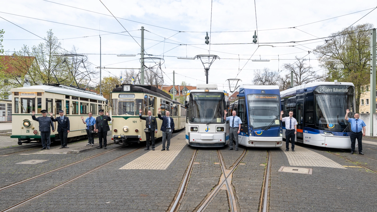 Historische und moderne Straßenbahnen stehen nebeneinander im Depot