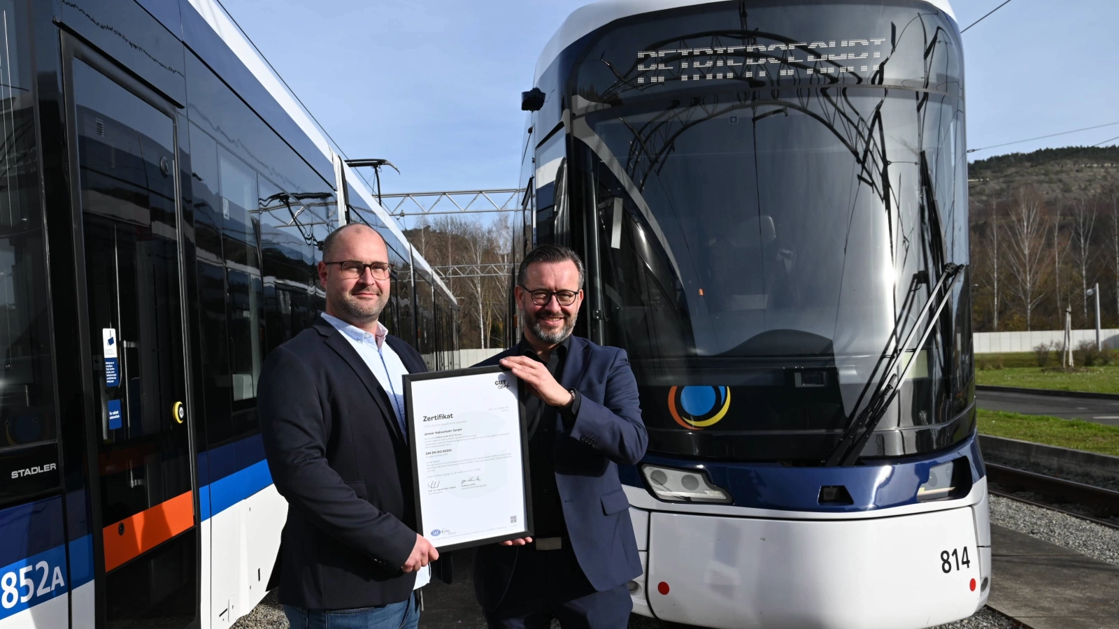 Gemeinsam zertifiziert: Steffen Gundermann (Jenaer Nahverkehr und JES) und Christian Lindau (links, Stadtwerke Energie Jena-Pößneck) präsentieren das ISO-50001-Zertifikat für das neue Energiemanagementsystem. 