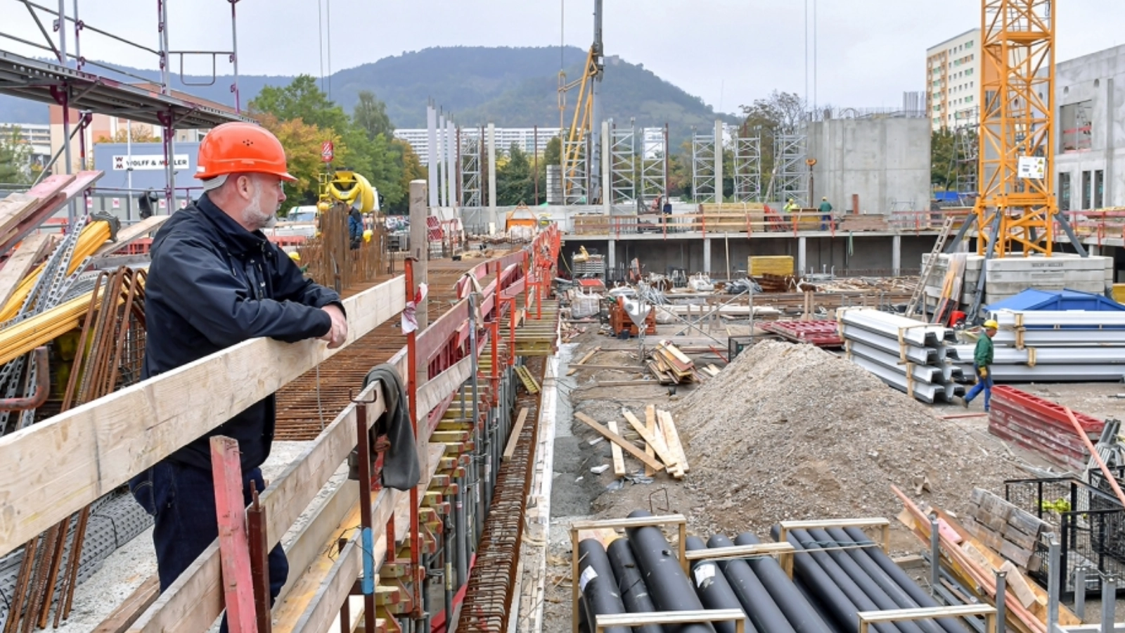 Projektleiter Heuthe blickt über die Baustelle der neuen Sportschwimmhalle in Jena-Lobeda.