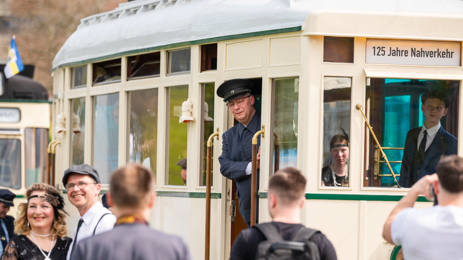 Besucherinnen und Besucher vor einer historischen Straßenbahn.