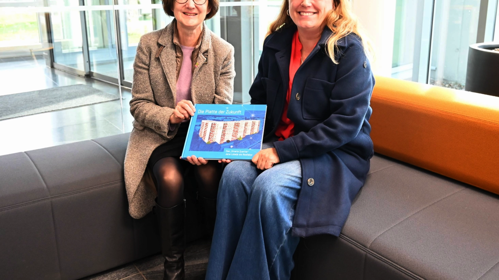 Doris Weilandt (links) und Tina Schnabel präsentieren das Buch „Die Platte der Zukunft. Das Smarte Quartier Jena-Lobeda als Reallabor“, das ab sofort im Stadtwerke-Kundencenter erhältlich ist. 