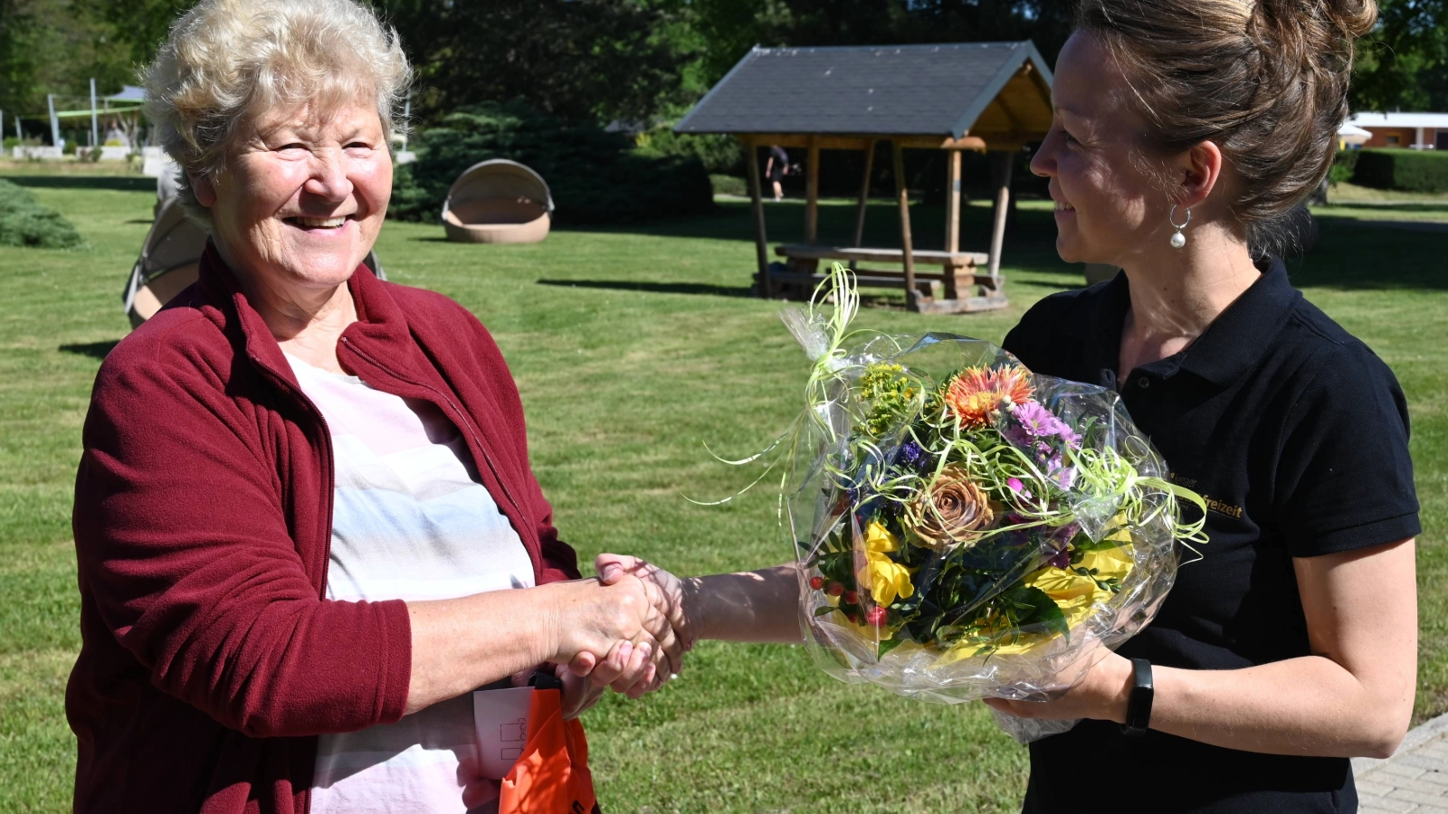 Eine Frau überreicht einen Blumenstrauß