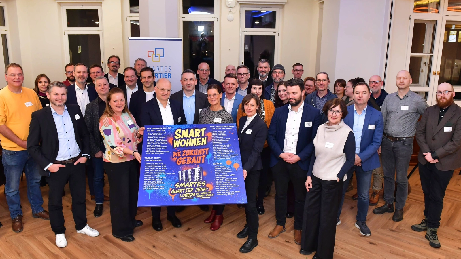 Gruppenbild: Gemeinsamer Abschluss: Alle Projektpartner kamen bei der Abschlussveranstaltung des Smarten Quartier Jena-Lobeda nochmals im Volkshaus Jena zusammen. Das Modellprojekt lief über fünf Jahre und entwickelte neue Ansätze für den Wohnungsbestand.  