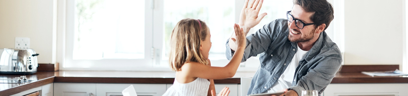 Ein Vater sitzt mit seiner Tochter am Tisch