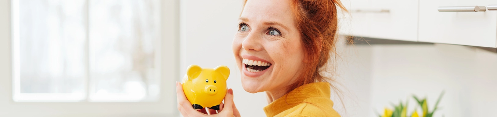 Eine Frau hält ein Sparschwein in der Hand
