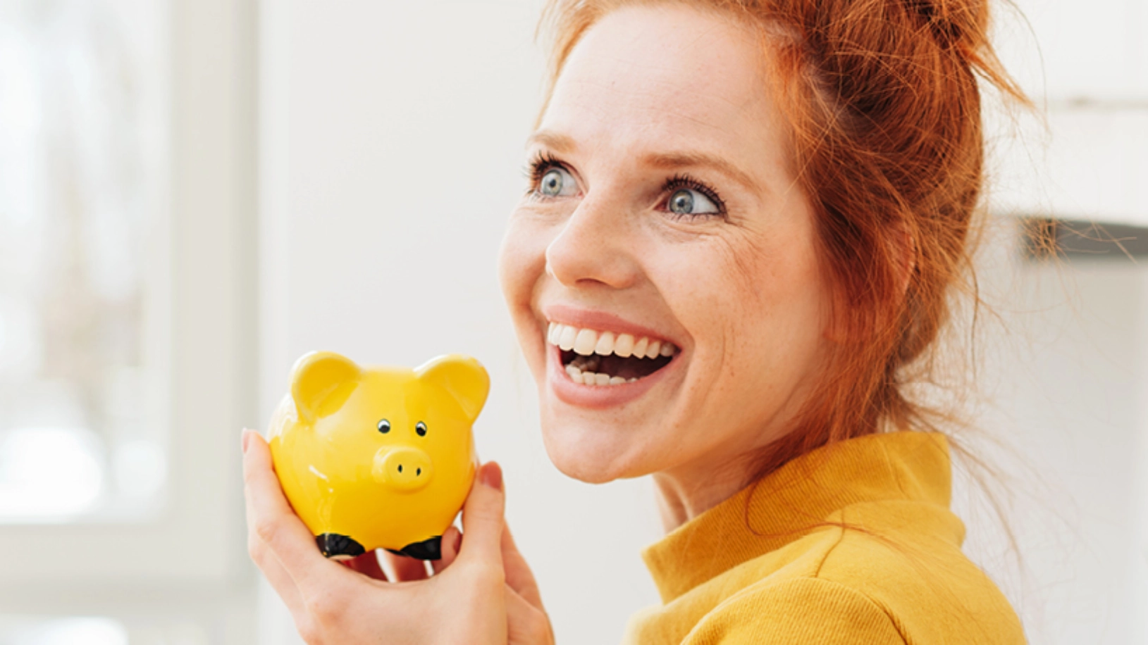 Eine Frau hält ein Sparschwein in der Hand