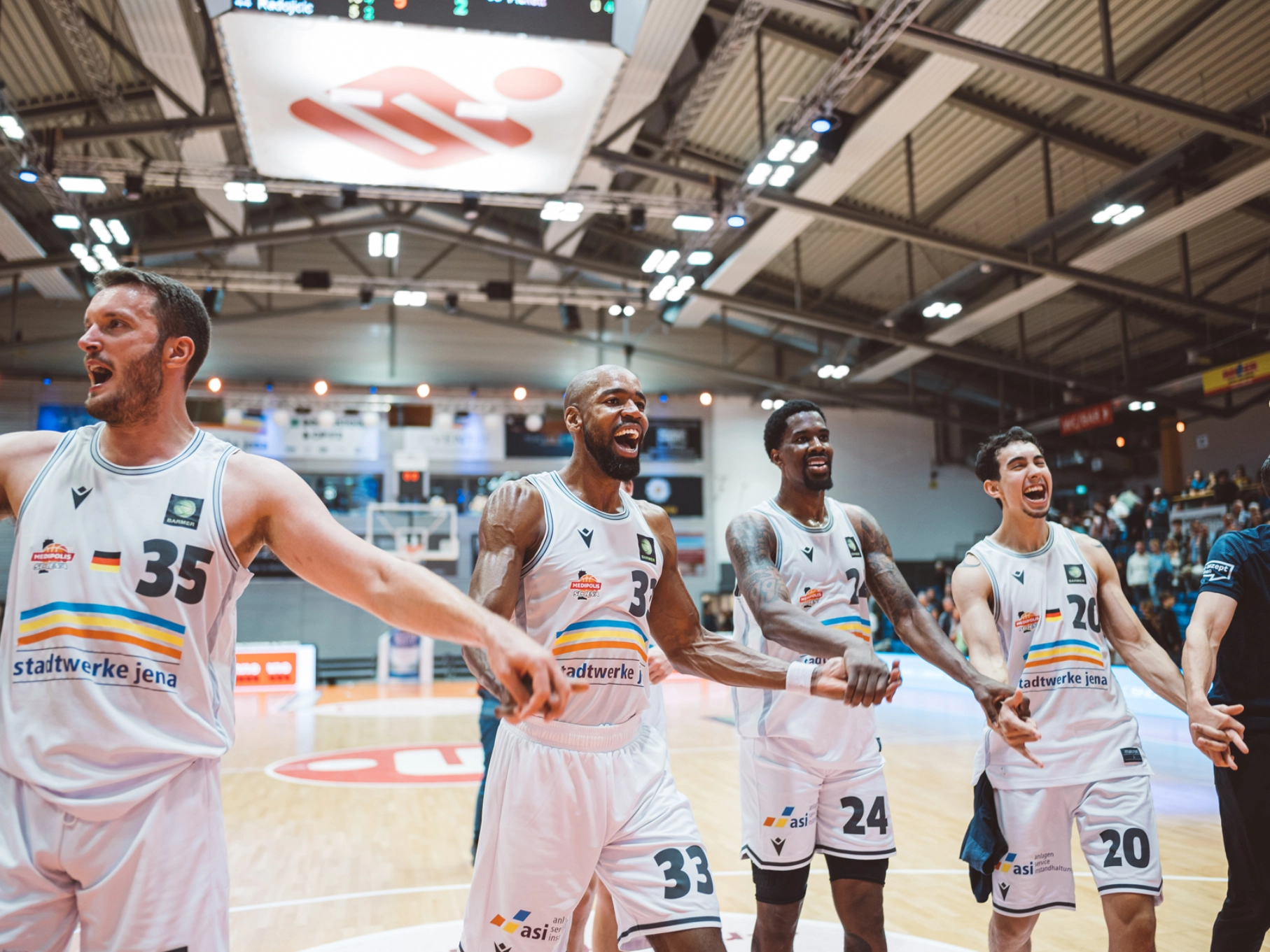 Basketballer jubeln in der Sparkassenarena auf dem Spielfeld.