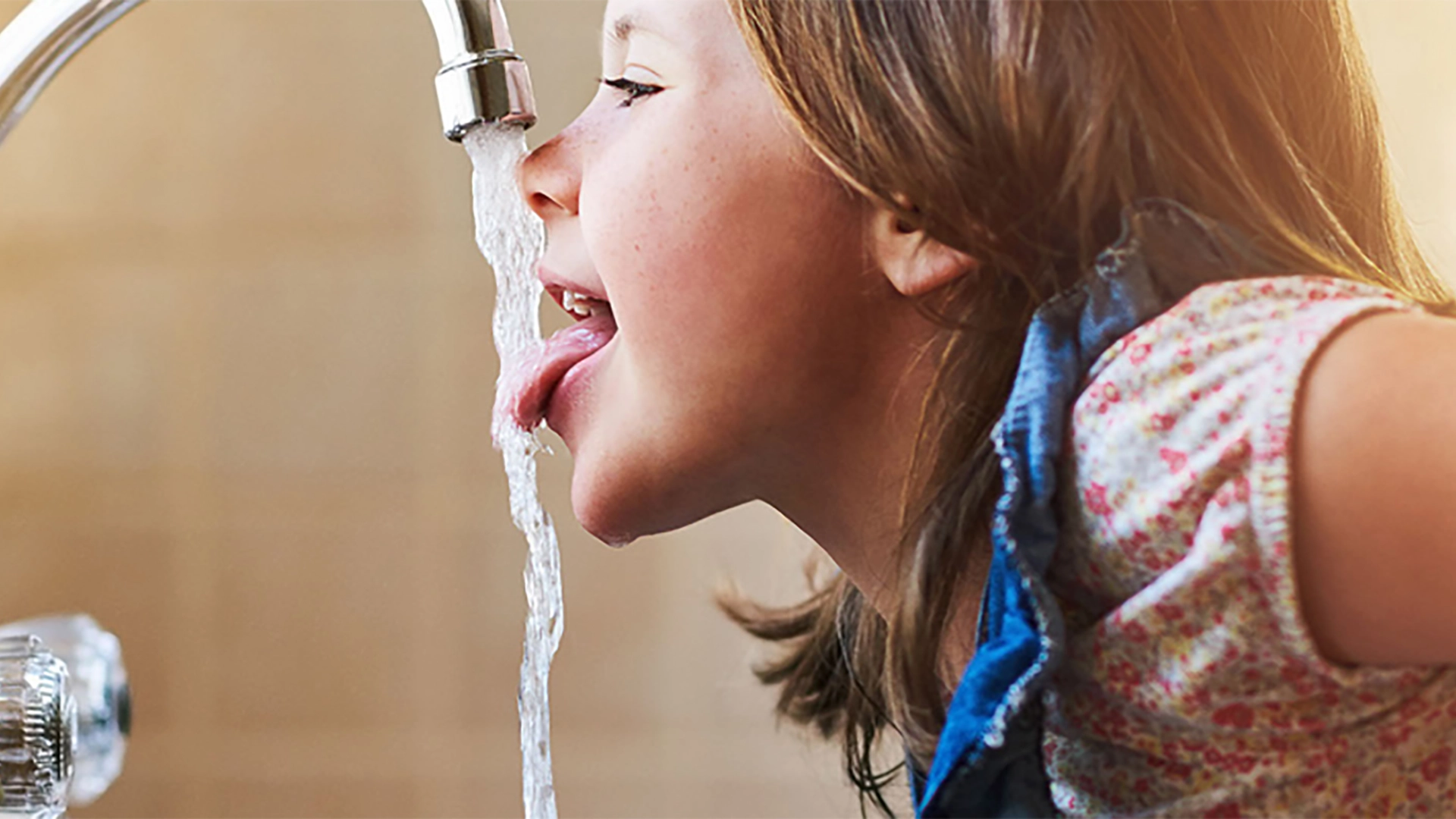  Kind trinkt aus Wasserleitung