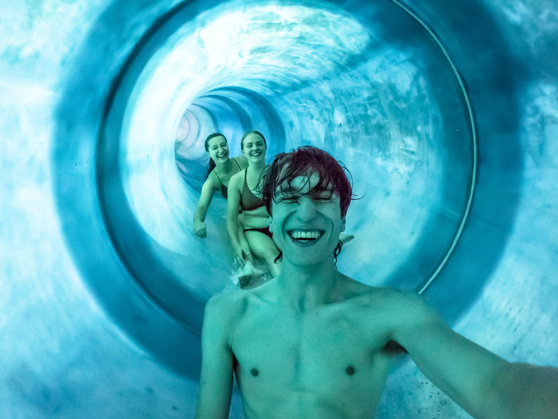Drei Junge Personen rutschen eine Rutsche im GalaxSea herunter