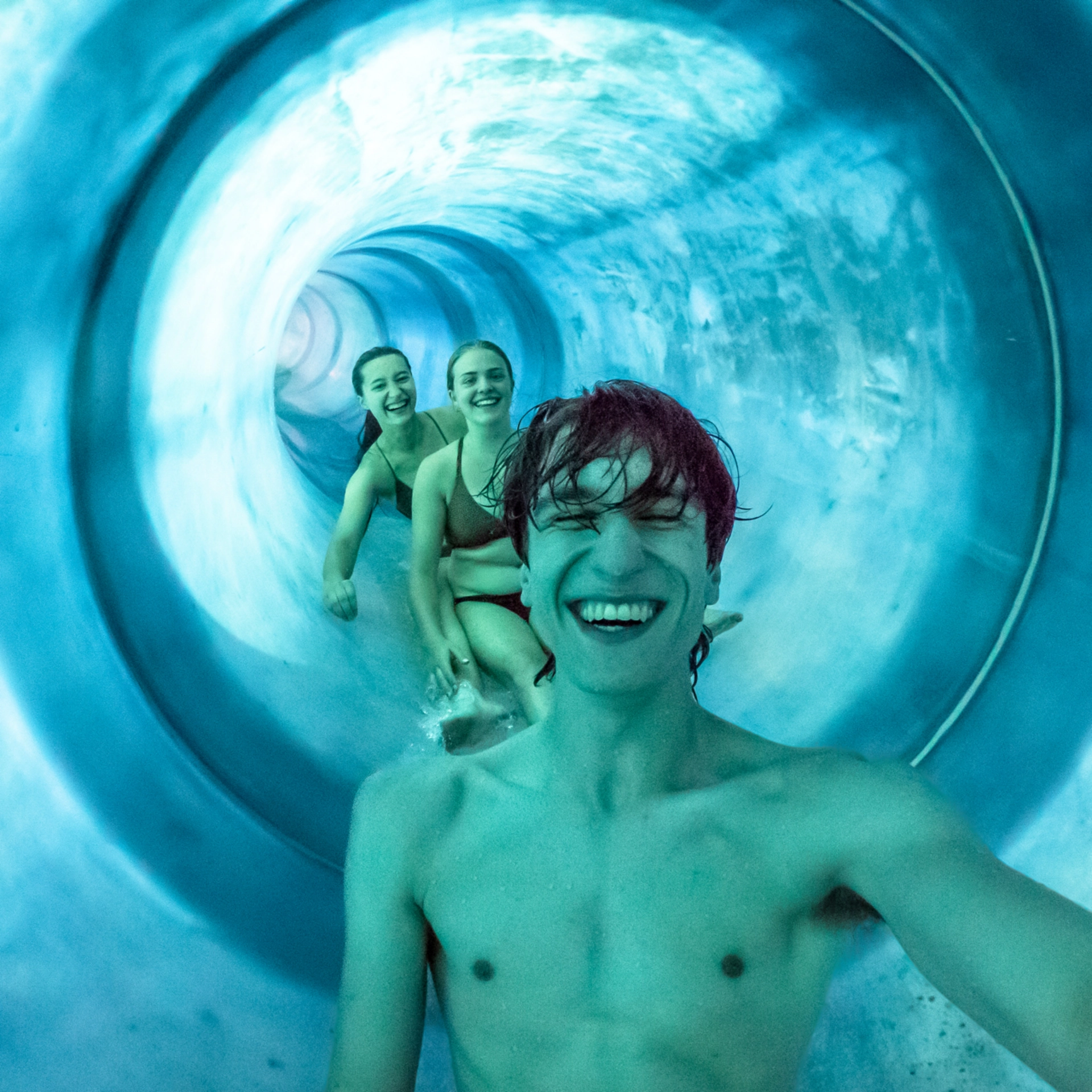 Drei Junge Personen rutschen eine Rutsche im GalaxSea herunter