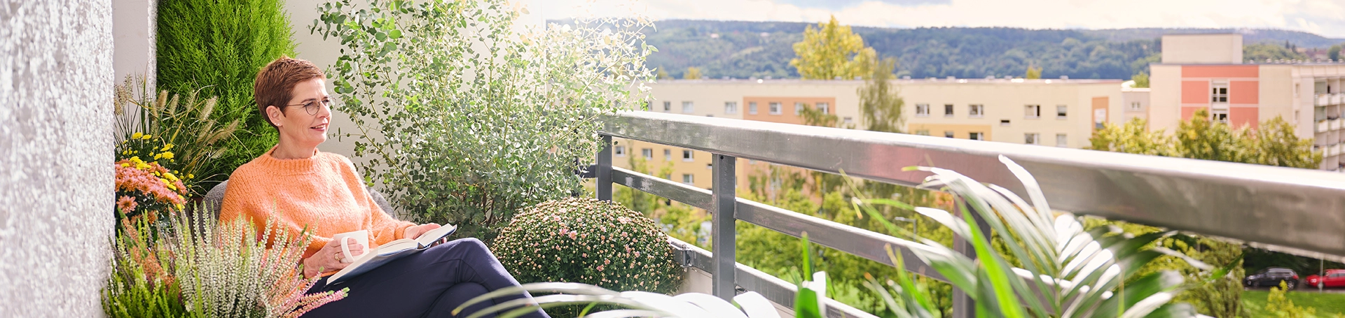 Eine Frau sitzt im Smarten Quartier auf einem Balkon