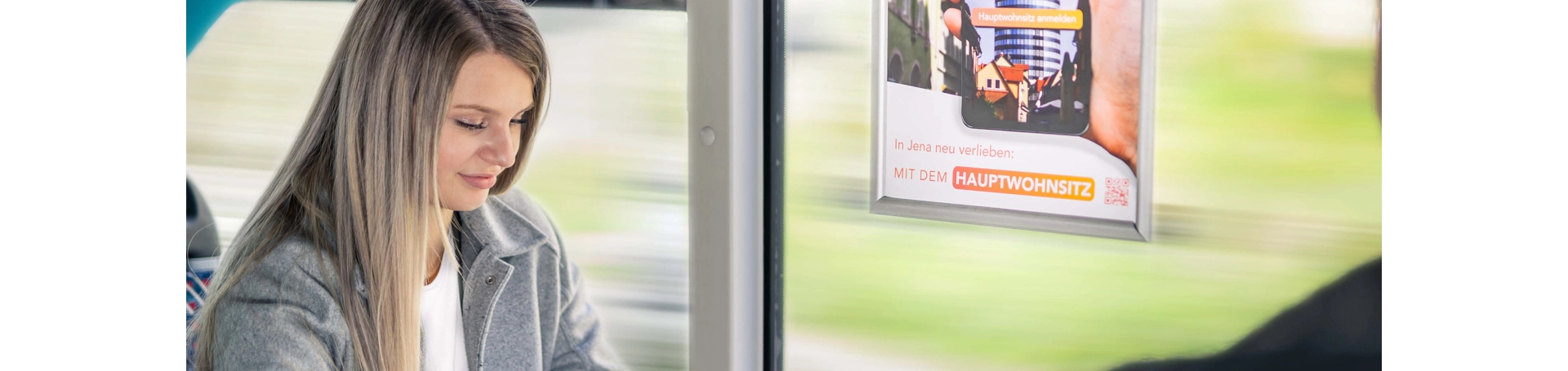 Frau mit Handy in einer Straßenbahn