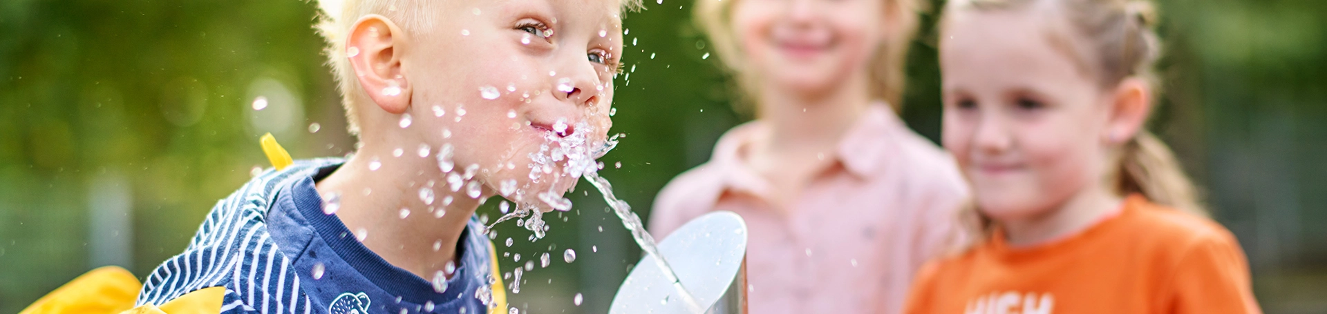Kinder stehen am Wasserquartier Trinkbrunnen 